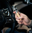 SPS - Natural Inhaler for Mental Stress Soothe Your Mind held in hand while driving a car.